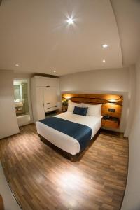 - une chambre avec un grand lit dans l'établissement Hotel Boutique Maria, à Morelia