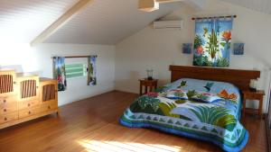 a bedroom with a bed and a wooden floor at Résidence des îles in Le Marin