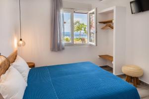 a bedroom with a blue bed and a window at Pension Ageri in Potos