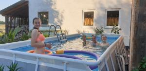 una mujer y tres niños jugando en una piscina en Iowa Room, en Memmingen