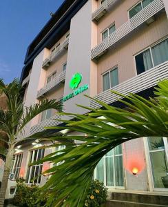 a building with a green sign in front of it at Oasis Hotel in Cajazeiras