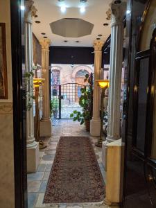 un pasillo de un edificio con columnas y una alfombra en D'Elite Room & Breakfast, en Ferrara