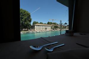two pairs of tongs sitting on a table next to a river at Hotel Bell'arrivo by Dori in Peschiera del Garda