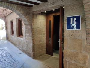 an entrance to a building with a r sign on the door at Hotel Rey Sancho in Navarrete