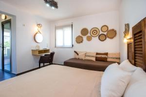 a bedroom with a bed and a desk with a chair at Studios Lotos in Potos