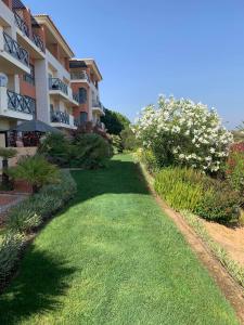 a building with a yard with green grass and flowers at Corcovada Lote 35 in Albufeira