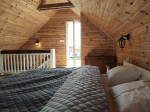 a bedroom with a bed in a wooden cabin at Srokowski Dwór 1 - Stara Kuźnia - Prywatna Sauna ! in Srokowo