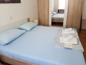 a bedroom with a bed with towels and a mirror at Apartment Skale in Senj