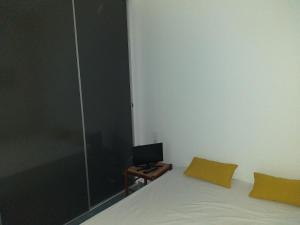 a bedroom with a bed and a desk with a monitor at Détente in Valras-Plage
