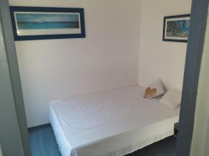 a bedroom with a white bed with a picture on the wall at Détente in Valras-Plage