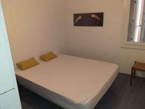 a small bedroom with a bed with white sheets at Détente in Valras-Plage