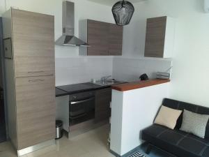 a small kitchen with a sink and a couch at Détente in Valras-Plage