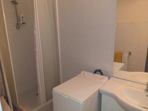 a white bathroom with a toilet and a sink at Détente in Valras-Plage