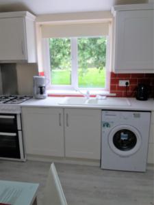 a kitchen with a washing machine and a window at Lettermore 1 Apartment in Rathdrum