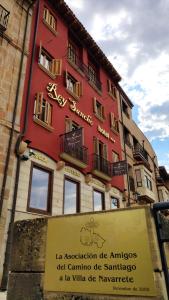 een rood gebouw met een bord ervoor bij Hotel Rey Sancho in Navarrete