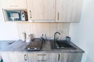 a kitchen with a sink and wooden cabinets at Pokoje Iga in Władysławowo
