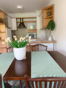 a kitchen with a table with a vase of flowers on it at Apartament Grunwaldzka in Sopot