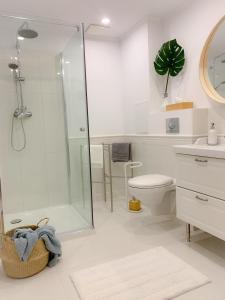 a bathroom with a shower and a toilet and a sink at Apartament Grunwaldzka in Sopot