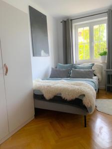 una camera da letto con letto, cuscini e finestra di Apartament Grunwaldzka a Sopot