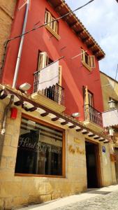 a red building with a window and a balcony at Hotel Rey Sancho in Navarrete