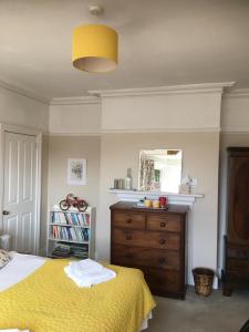 1 dormitorio con cama amarilla y vestidor en Old Church House, en Newport
