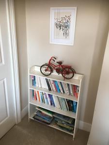 uma estante cheia de livros com uma bicicleta. em Old Church House em Newport