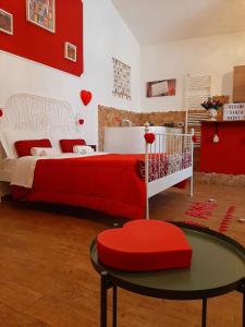 una camera da letto rossa e bianca con un letto e un tavolo di La casina a San Severo