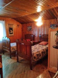 um quarto com 2 camas e um tecto de madeira em Domik s saunoy na Ogiyenko em Kamianets-Podilskyi