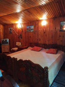 um quarto com uma cama grande num quarto de madeira em Domik s saunoy na Ogiyenko em Kamianets-Podilskyi
