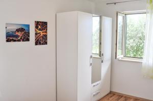 a room with a white cabinet and two pictures on the wall at Apartment Lavandula in Labin