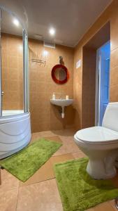 uma casa de banho com um WC branco e um lavatório. em Urban Apartment em Riga