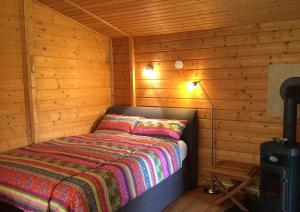 ein Schlafzimmer mit einem Bett in einer Holzhütte in der Unterkunft Romantic Wooden Lodge,Sauna,Schwimmteich,alleinstehend,absolut ruhig in Hessisch Oldendorf