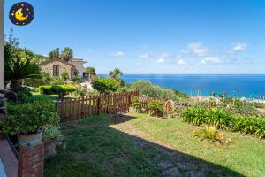 a yard with a fence and the ocean in the background at Villa Giraluna in Castellabate