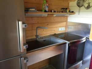 eine Küche mit Spüle und Kühlschrank in der Unterkunft Romantic Wooden Lodge,Sauna,Schwimmteich,alleinstehend,absolut ruhig in Hessisch Oldendorf