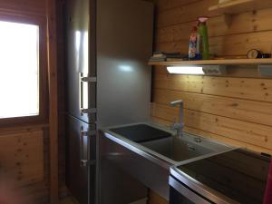 eine Küche mit Spüle und Kühlschrank in der Unterkunft Romantic Wooden Lodge,Sauna,Schwimmteich,alleinstehend,absolut ruhig in Hessisch Oldendorf