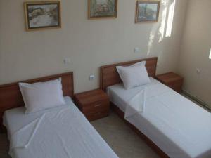 dos camas sentadas una al lado de la otra en un dormitorio en Versai Hotel en Svishtov
