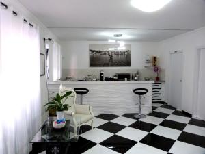 una cocina con suelo a cuadros en blanco y negro en Clelia's Boutique Rooms & Suites, en La Maddalena