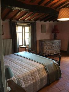 um quarto com uma cama grande e uma janela em Borgo Vetrianello em Lucca