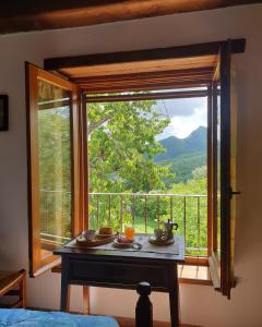 Camera con finestra, tavolo e vista di Agriturismo Il Falco del Monte Fumaiolo ad Alfero