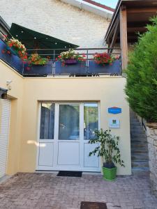 una puerta blanca con flores en el balcón en L'Oustalou en Viéville