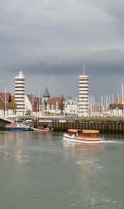 un barco en el agua cerca de un puerto con edificios en Le Studio Goëland, en Trouville-sur-Mer