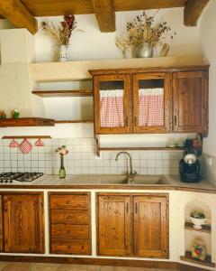 una cucina con armadi in legno e lavandino di Agriturismo Il Falco del Monte Fumaiolo ad Alfero