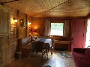 ein Esszimmer mit Tisch und Couch in der Unterkunft Romantic Wooden Lodge,Sauna,Schwimmteich,alleinstehend,absolut ruhig in Hessisch Oldendorf