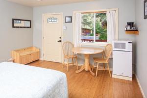 a bedroom with a table and two chairs and a window at Steller Inn in Seward