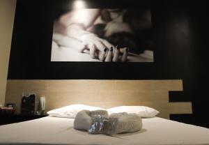 IBIZA GOLDEN MOTEL في فرانكا: غرفة نوم بسرير مع صورة لامرأة بيدها