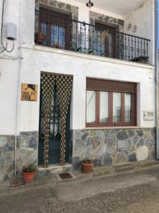um edifício branco com uma porta e uma varanda em VUT La Villarina em Sancti Spíritus