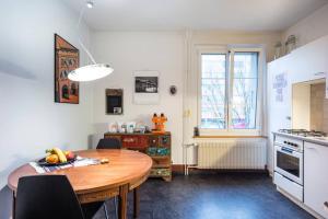 eine Küche mit einem Holztisch und einem Esszimmer in der Unterkunft -TheUrbanist- in Bern