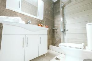 a bathroom with a white sink and a toilet at Design Suites Efharis (Sauvignon) in Nea Peramos
