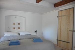 a bedroom with a bed with two blue pillows on it at Lykkegård - Glück im ehemaligen Weinkeller in Tönning