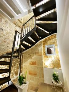 una escalera de caracol en un edificio de piedra con dos macetas en White Home, en Bisceglie